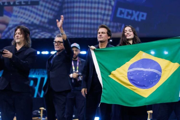 Elenco de de "Bailarina" com bandeira do Brasil em painel na CCXP24